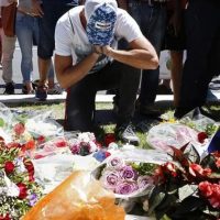 A man reacts near bouquets of flowers in Nice France