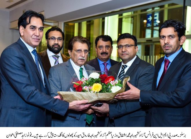 راجہ محمد اشفاق وزیراعظم آزاد کشمیر راجہ فاروق حیدر کو پھولوں کا گلدستہ پیش کر رہے ہیں